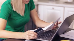 woman with a credit card and laptop paying medical bills
