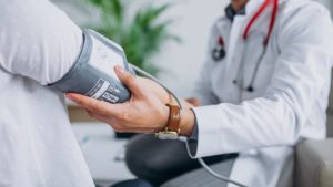 doctor taking the blood pressure of a patient